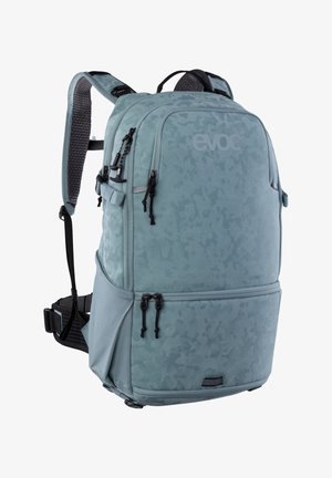 Grande zaino azzurro chiaro con più scomparti con cerniera, spallacci imbottiti, cintura in vita e motivo mimetico discreto.