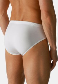 Witte katoenen slipjes met een strakke pasvorm, elastische tailleband en een gladde textuur. Het ontwerp heeft minimale naden en een klassieke snit.