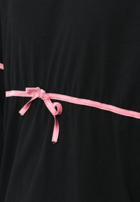 Rochie din țesătură neagră, cu centură din satin roz legată în talie, având o textură netedă și o croială lejeră. Dungi subțiri roz accentuează designul.