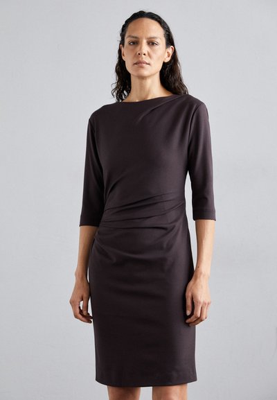 Robe ajustée marron foncé avec un décolleté bateau, des manches trois-quarts et des détails froncés à la taille. Texture de tissu lisse.