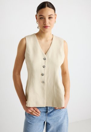 Beige sleeveless top with a V-neck, featuring four decorative silver-tone buttons, set against a light background. Casual fit and clean design.