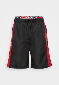 Black swim shorts with red side panels, elastic waistband with drawstring, and logo detail. Made of smooth, lightweight fabric.
