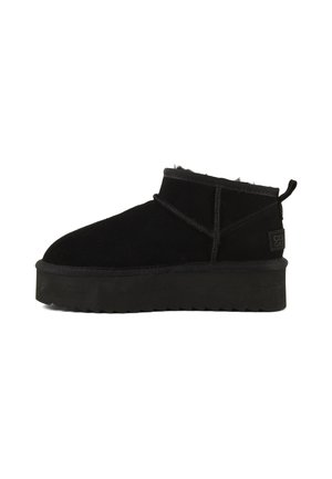 Schwarzer Wildleder-Stiefelette mit dicker Plateausohle, sichtbaren Nähten, Zuglasche an der Ferse und Fleece-Futter im Kragen.