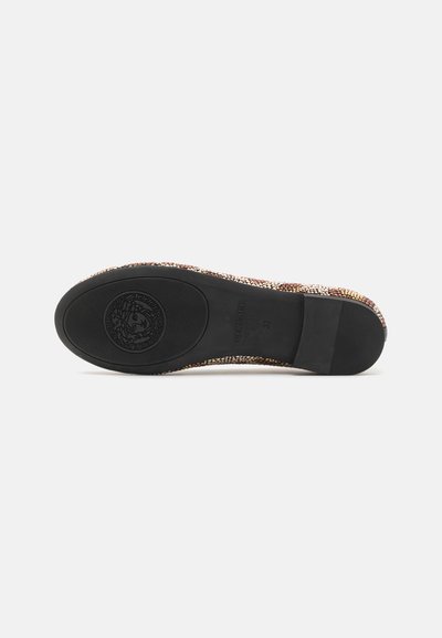 Vävd tyg slip-on sko med ett mönstrat ovandel i jordnära nyanser, svart gummisula och präglad logotyp på undersidan.