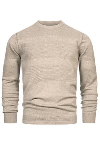 Világos bézs pulóver texturált mintával, amely vízszintes sávokat tartalmaz. Bordázott mandzsetták és gallér. Puha, kötött anyagú, testre simuló szabással.