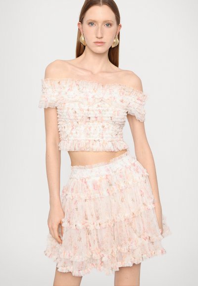 Top cu umeri descoperiți, cu volane și fustă mini stratificată dintr-un material transparent, de culoare roz pal, cu modele florale. Talie elastică texturată pe fustă.