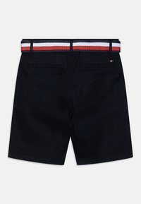 Tmavě modré kraťasy s tkaným vícolorým pásem, který má červené, bílé a námořnické pruhy. Dvě zadní kapsy s čistým zakončením.