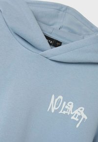 Lichtblauwe hoodie met een voorkraal en witte bedrukte tekst "NO LIMIT" op de linkerkant van de borst. Gemaakt van zacht katoen.