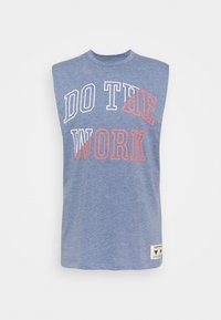 Camiseta sin mangas azul con el texto "HAZ EL TRABAJO" en blanco y naranja. Fabricada con un tejido suave y texturizado, con un corte relajado.