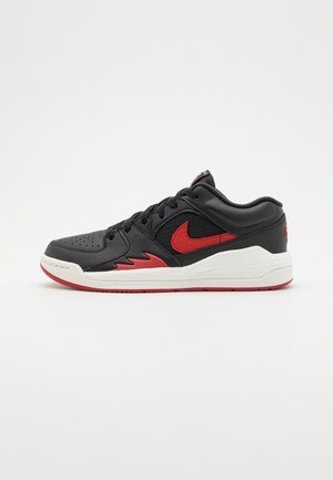 Schwarze Leder Sneaker mit roten Akzenten, perforierter Zehenpartie und gepolstertem Kragen. Verfügt über eine weiße Zwischensohle und eine Gummisohle mit strukturiertem Profil.