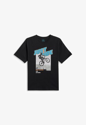 Czarna koszulka z grafiką rowerzysty wykonującego skok i tekstem „JUST RIDE” dużymi niebieskimi literami oraz „Stay fearless and extreme” poniżej.
