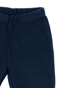 Tmavomodré fleeceové nohavice s elastickým pásom, ktoré majú mäkkú textúru a rovný strih nohavíc.