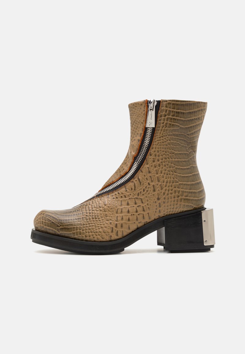 Bež ankle škornji s kroko embosiranjem, stranskim zadrgo in kovinskimi detajli; imajo robusten črn peto za stabilnost.