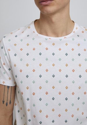 T-shirt bianco a maniche corte con un motivo a diamante multicolore in arancione, verde e blu marino. Realizzato in morbido cotone con scollatura a girocollo.