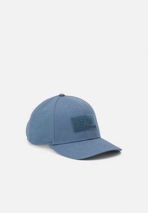 Cappellino da baseball in cotone blu con un design strutturato, caratterizzato da una patch logo testurizzata sul davanti e una visiera curvata.