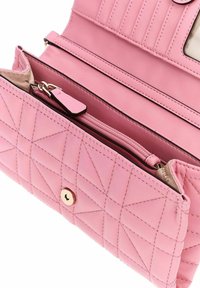 Portefeuille rose en cuir matelassé avec compartiment zippé, plusieurs emplacements pour cartes et une fermeture à bouton-pression, présenté ouvert sur un fond blanc.