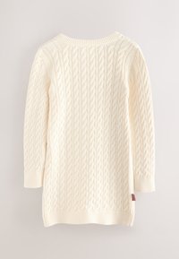 Kremas spalvos megztinis su pintiniu raštu, ilgomis rankovėmis ir apvalia iškirpte. Rankogaliai ir apačia yra riboto mezgimo, šone yra mažytė spalvota etikėtė.