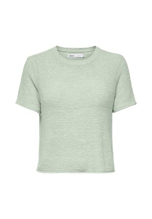 Pull en maille vert clair à manches courtes avec col rond et coupe légèrement courte, tissu texturé, et étiquette de marque à l'intérieur du col.