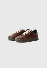 Brune slangeskinsprint sneakers med en struktureret finish, cremefarvede snørebånd og sort inderside. Flad gummisål med et fleksibelt design.