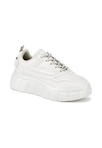 Zapatilla blanca con suela gruesa y texturizada, parte superior lisa y detalles en gris; cuenta con detalles perforados y una lengüeta trasera para facilitar el calzado.