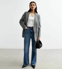 Grå kavaj över en vit topp, matchad med högmidjade blå jeans. Svart väska och klackskor med spetsig tå fulländar outfiten. Enkelt, elegant design.