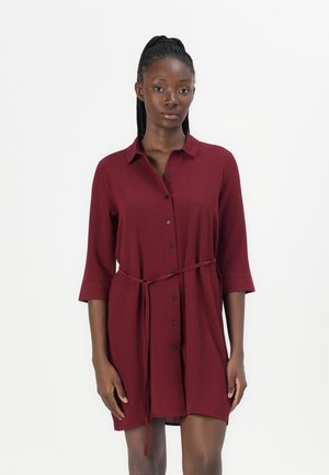 Abito camicia bordeaux realizzato in tessuto leggero, con apertura anteriore a bottoni, colletto, maniche a tre quarti e vita legata.