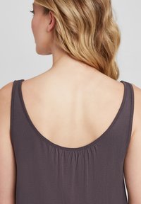 Graues, ärmelloses Oberteil mit rundem Rückenausschnitt und gerafftem Detail am Halsauschnitt. Der Stoff wirkt weich und glatt, geeignet für alltägliches Tragen.