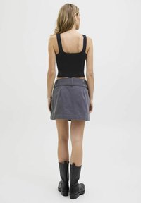 Must have mustakate ribade, hallitan denim seelik külgpocketitega ja mustad põlvikud. Lihtne disain, keha lähedane kuju ja matt tekstuur.