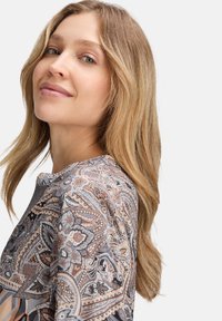 Bluzka z wzorem z miękkiego, lekkiego materiału, ozdobiona zawiłymi wzorami paisley w odcieniach szarości, beżu i terakoty, z okrągłym dekoltem.