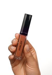 Transparente Tube mit flüssigem Lippenstift und schwarzem Deckel, in einem warmen Nude-Ton. Das Etikett trägt die Schriftzug "INGLOT" in fetter schwarzer Schrift.
