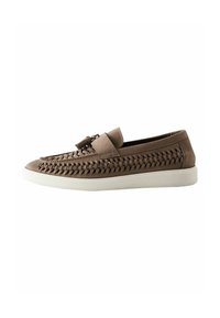 Brown leather slip-on shoe with woven detailing on the upper, flat white rubber sole, and a small decorative strap across the front.