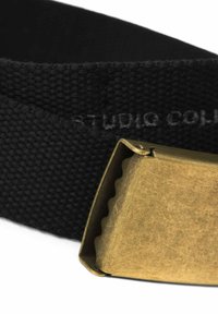 Black woven belt with a metal buckle. The buckle is brass with a slightly textured, matte finish and a serrated edge.