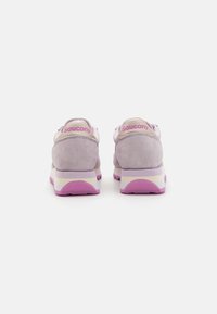 Sneakers in suede viola con una suola intermedia bianca e rosa. Presentano un accento posteriore metallico e un marchio sul tallone. Design semplice e arrotondato.