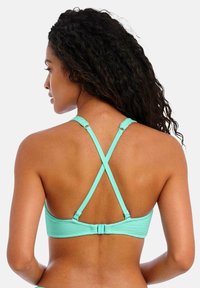 Tyrkysový sportovní podprsenka s texturovanou tkaninou, s křížovými ramínky a širokým páskem, nastavitelným háčkovým zapínáním na zádech.