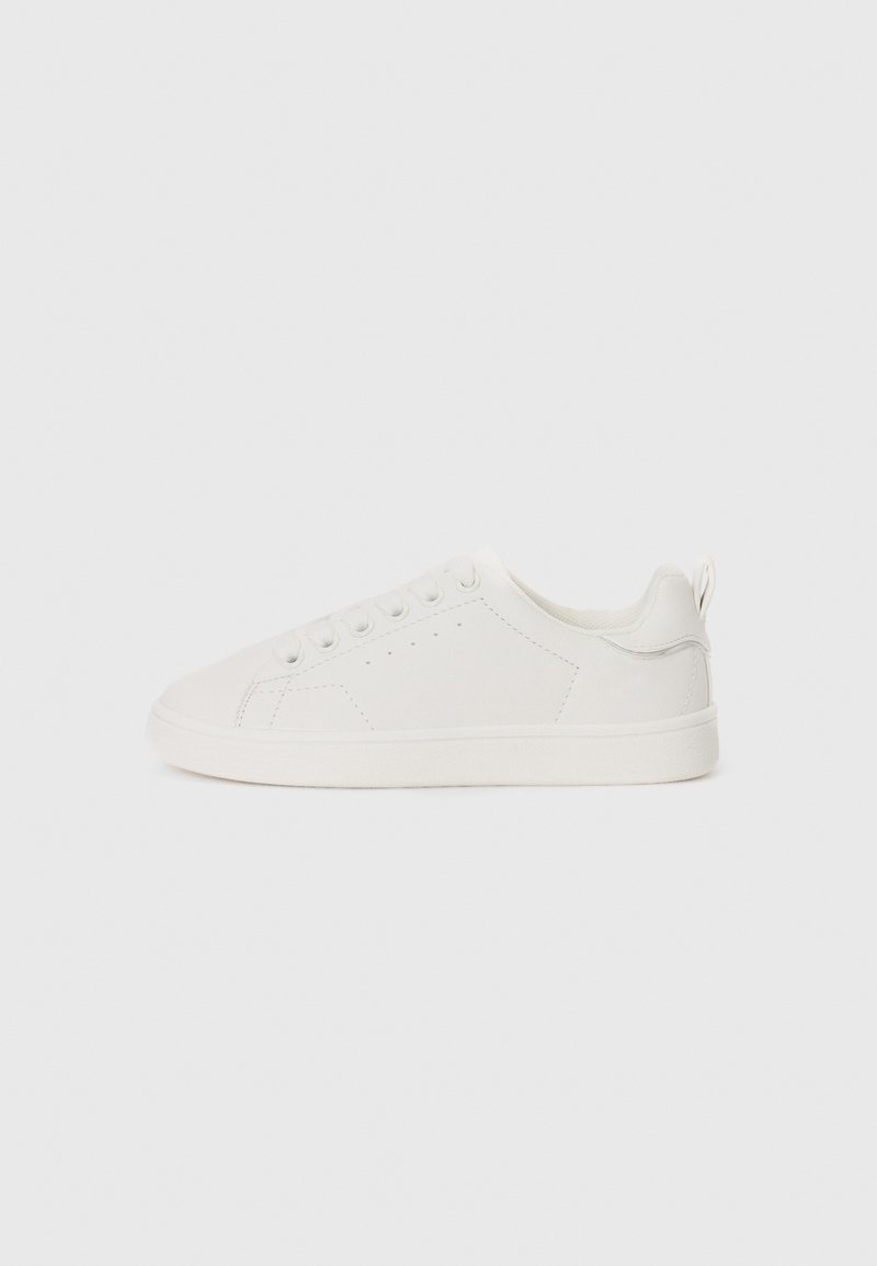 Białe skórzane sneakersy z płaską podeszwą, okrągłym noskiem, sześcioma oczkami i subtelnymi detalami przeszycia. Zawierają mały uchwyt przy pięcie.