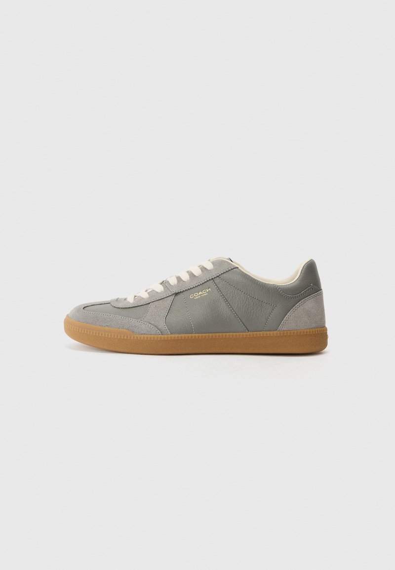 Gray leather and suede sneaker with cream laces and a gum rubber sole; features embossed logo and panel accents. Soft texture and minimalistic design.