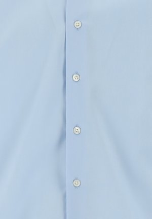 Camisa de botones azul claro con una textura suave, seis botones en la parte delantera y costuras en contraste.