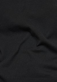 Schwarzer Strickstoff mit glatter Textur, der dezente Wellen und Falten aufweist und ein einfaches, einheitliches Design zeigt.