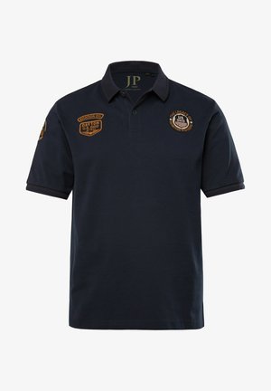 Marineblaues Poloshirt aus Baumwolle mit klassischem Kragen, kurzen Ärmeln und bestickten Abzeichen auf der Brust und dem Schulterbereich.