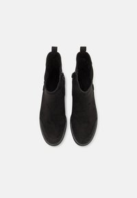 Bottes noires à la cheville avec une finition en daim lisse, dotées de zips latéraux, de languettes de tirage et de semelles en caoutchouc texturé.