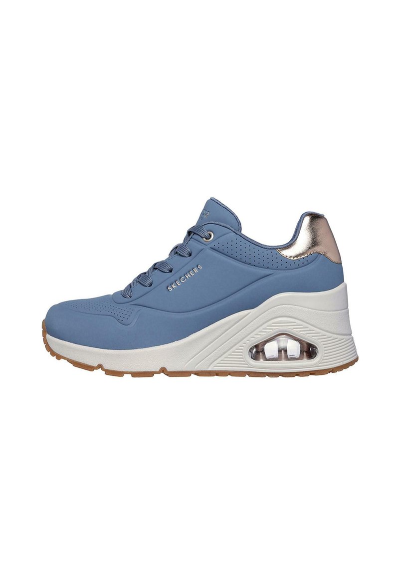 Zapatilla deportiva azul con un diseño elegante, suela de goma, cuello acolchado y acentos metálicos en el talón. Detalle de entresuela con amortiguación de aire.