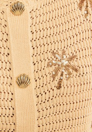 Beige knitted fabric with gold shell-shaped buttons and a gold sequin palm tree embellishment.