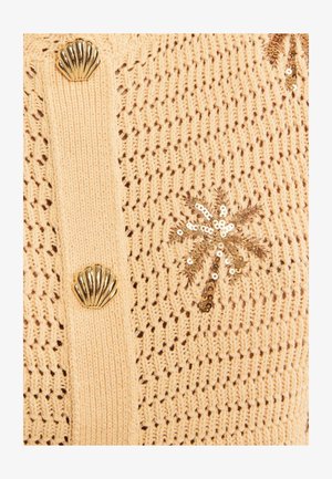 Beige knitted fabric with gold shell-shaped buttons and a gold sequin palm tree embellishment.