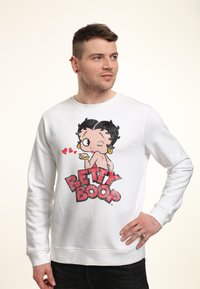 Sudadera blanca con un gran gráfico de Betty Boop, con colores vibrantes, contornos negros y texto que dice "BETTY BOOP" en rojo negrita.