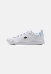 Sneakers bianchi in materiale sintetico, con un design low-top, chiusura con lacci e un logo di coccodrillo ricamato verde sul lato.