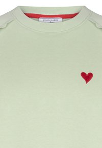 Ljusgrön sweatshirt i mjukt material med rundad halsringning, röda detaljer inuti kragen och en liten röd hjärtapplikation.