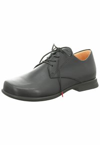 Chaussure en cuir noir avec un bout arrondi, fermeture à lacets et design minimaliste. Présente une texture lisse et une semelle en caoutchouc discrète.