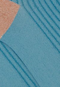 Tessuto blu con una trama a coste diagonali e un accento color pesca. Il materiale appare liscio con cuciture visibili.