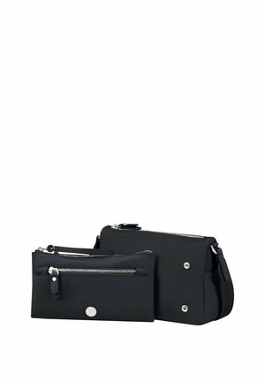 Zwei schwarze rechteckige Taschen mit silbernen Reißverschlüssen, eine kleinere Tasche vorne und eine größere Umhängetasche mit einem Riemen dahinter.