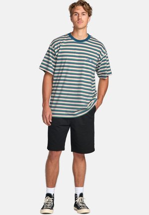 Stripet T-shirt med korte ærmer i grøn, pink og hvid med en teal krave; båret med sorte shorts og sorte høj-top sneakers.